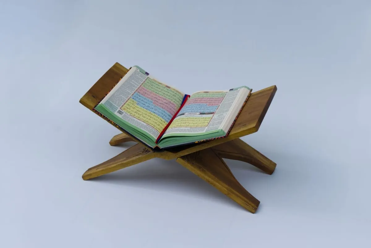An open colour-coded Tajweed Quran on a wooden stand
