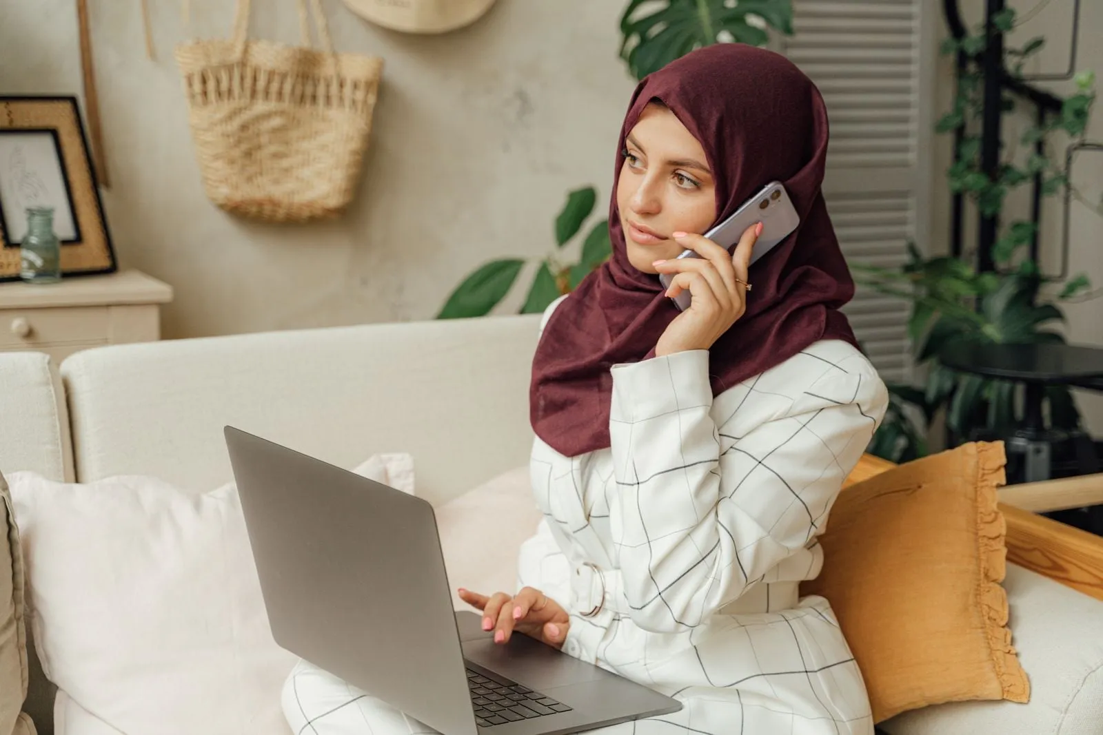 A woman in a headscarf with a laptop at home